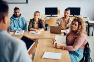 A group of social science degree students sitting at a table in a classroom.